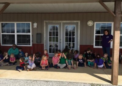 a group of children sitting on the porch of a building